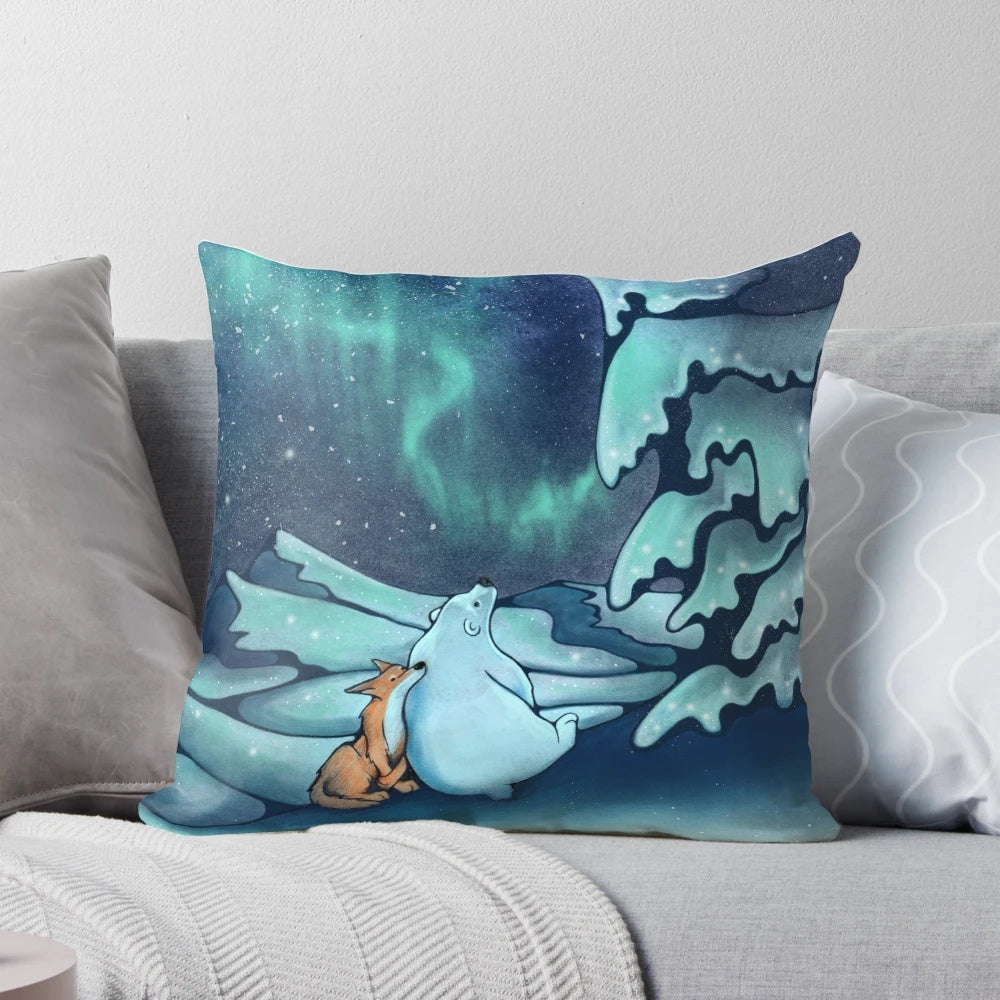 A soft, decorative pillow featuring a whimsical illustration of the northern lights, snow, and winter wildlife.