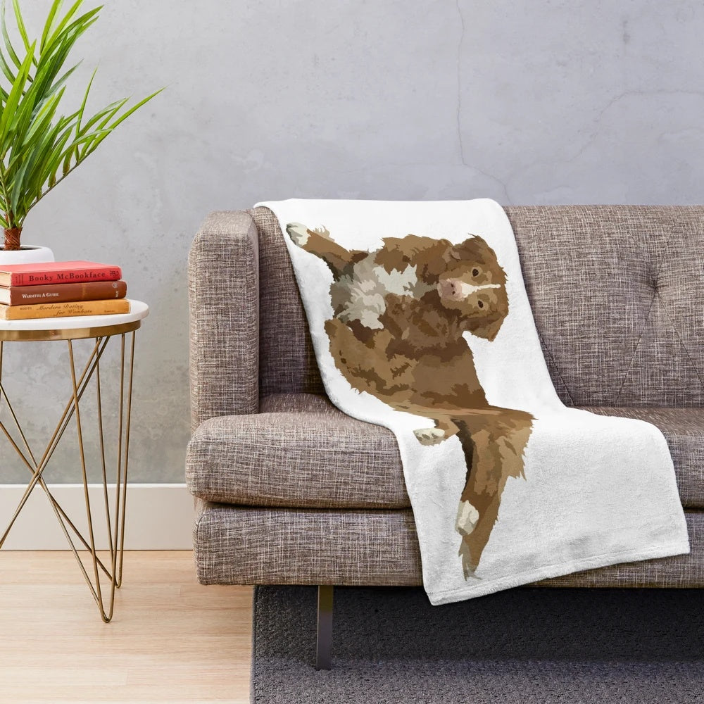 Nova Scotia Duck Tolling Retriever puppy on plush brown blanket