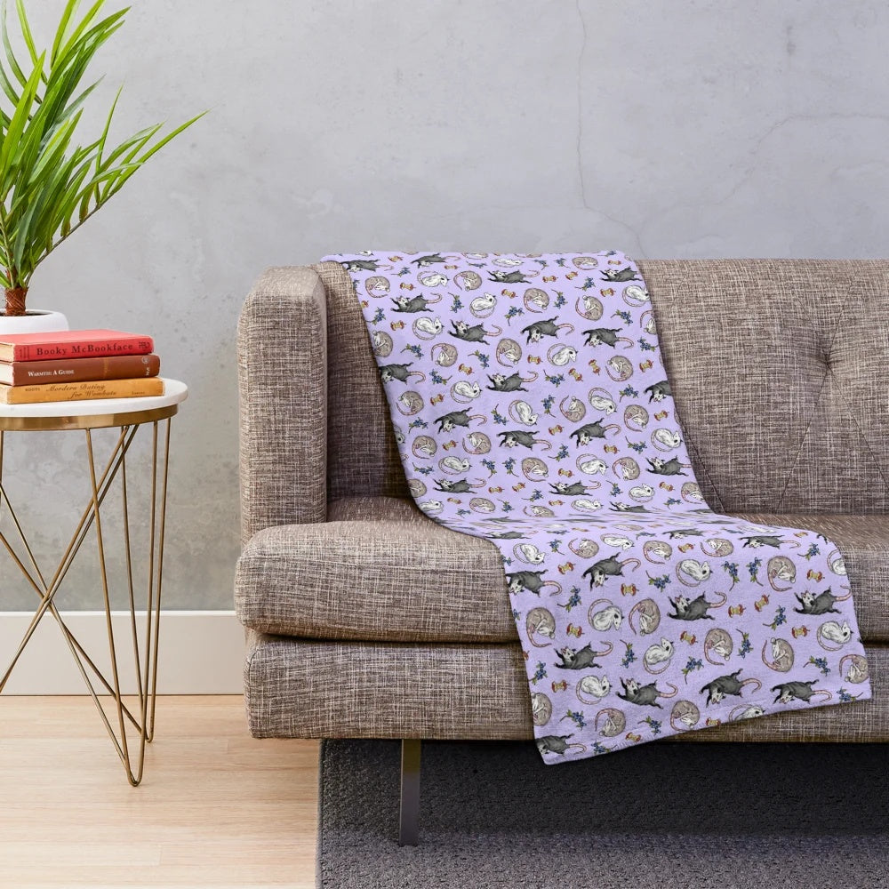 Soft and cuddly plush blanket featuring a cute opossum design in a nature-inspired woodland pattern