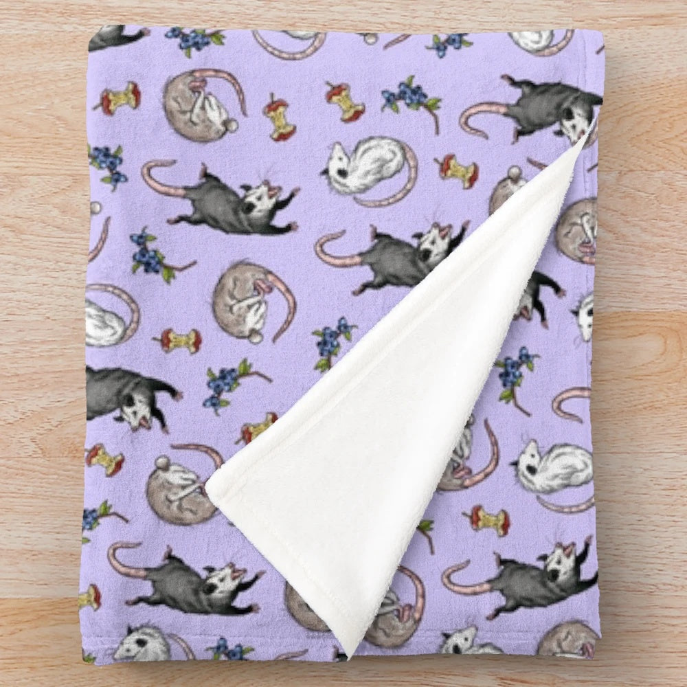 Soft and cuddly plush blanket featuring a cute opossum design in a nature-inspired woodland pattern