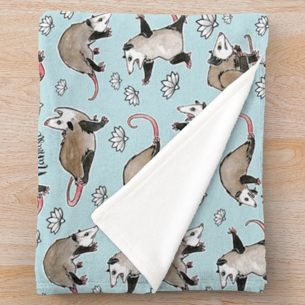 Cozy aqua plush blanket featuring cute opossums in yoga poses