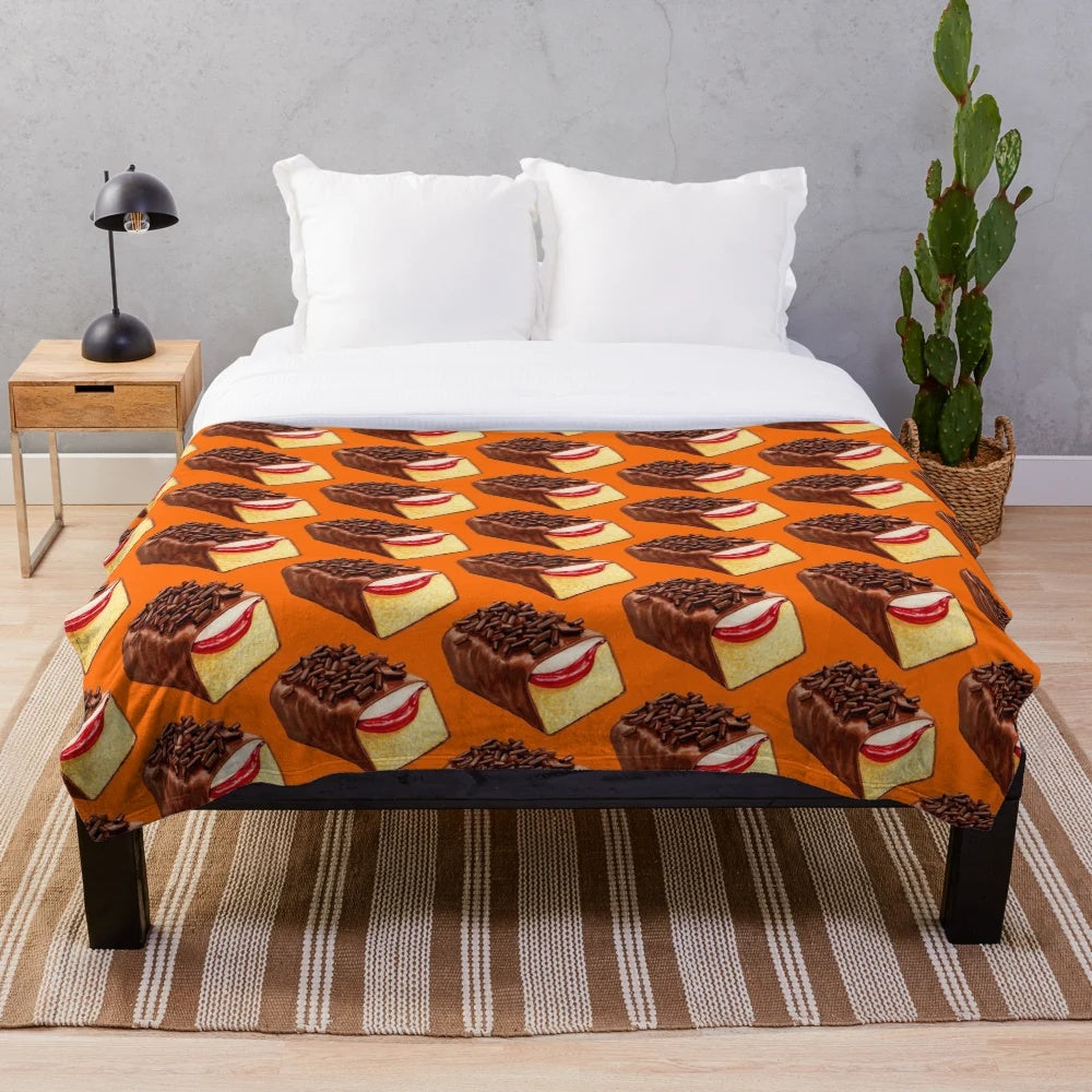 Orange plush blanket with a vintage, retro design inspired by the classic Mexican Gansito snack cake