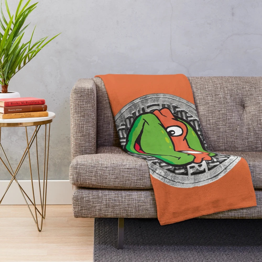 Orange plush blanket featuring the beloved cartoon character Michelangelo from Teenage Mutant Ninja Turtles