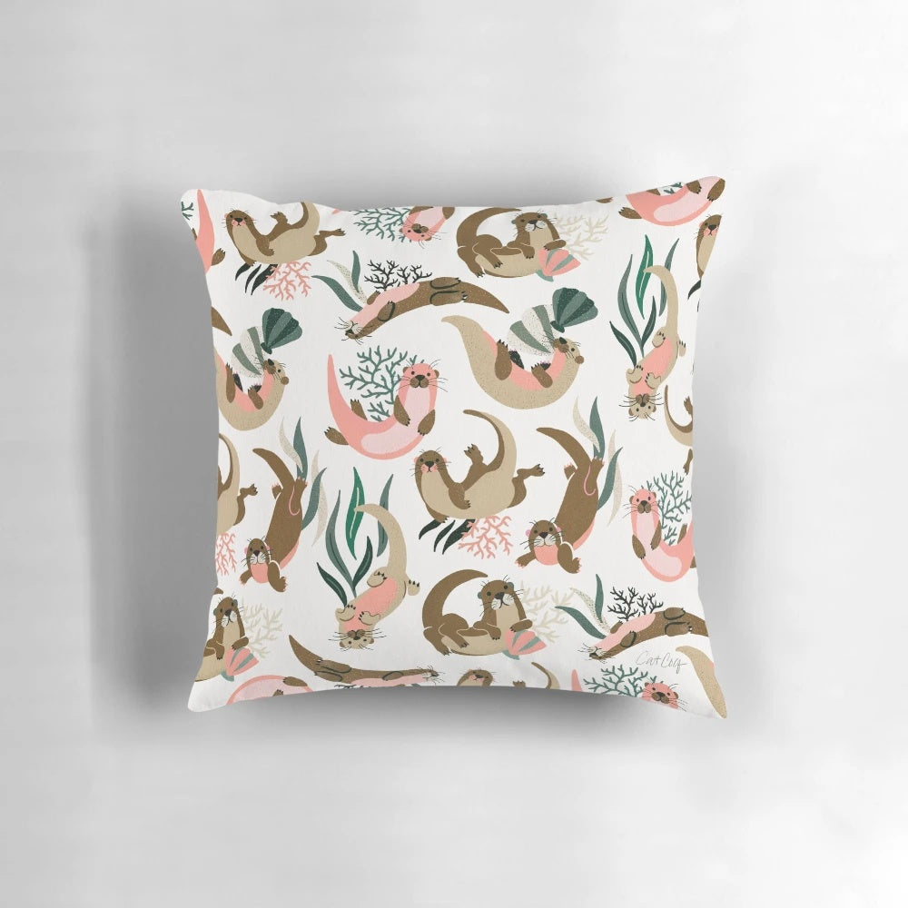 White pillow with a print of a cute sea otter or river otter.