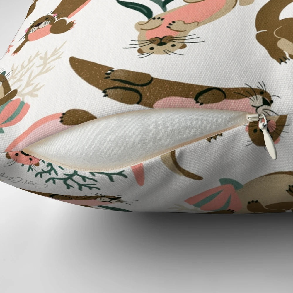 White pillow with a print of a cute sea otter or river otter.