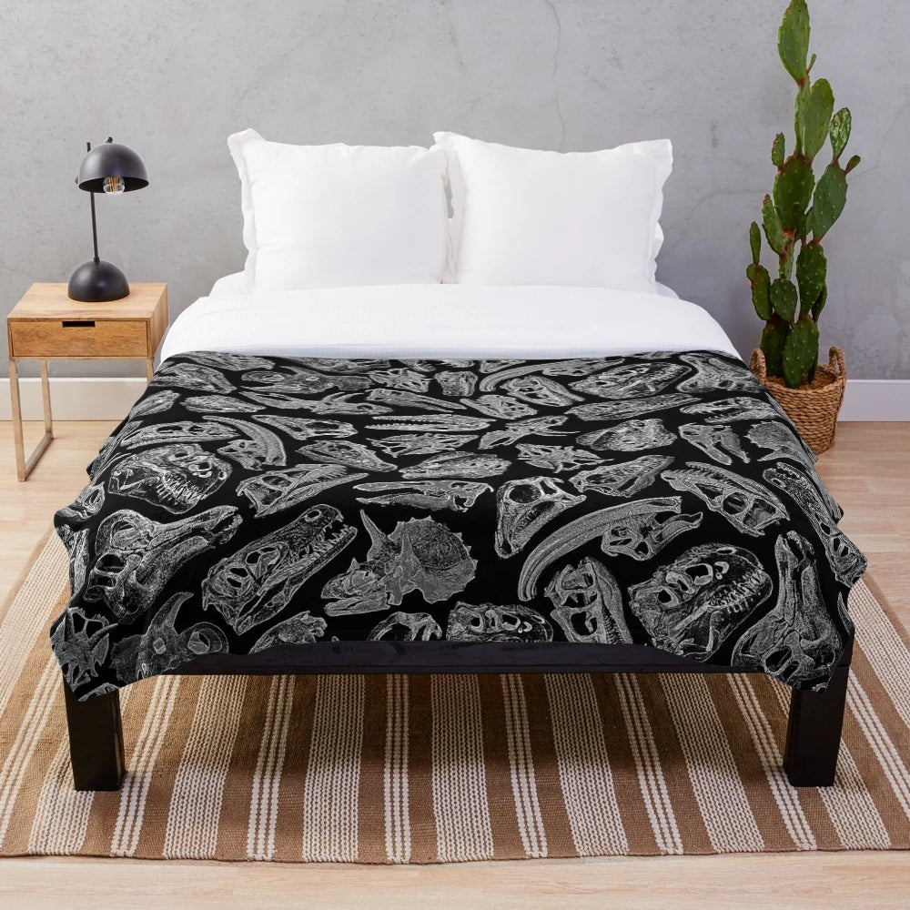 Plush blanket featuring a paleontology-inspired design with dinosaur fossils and skeletons