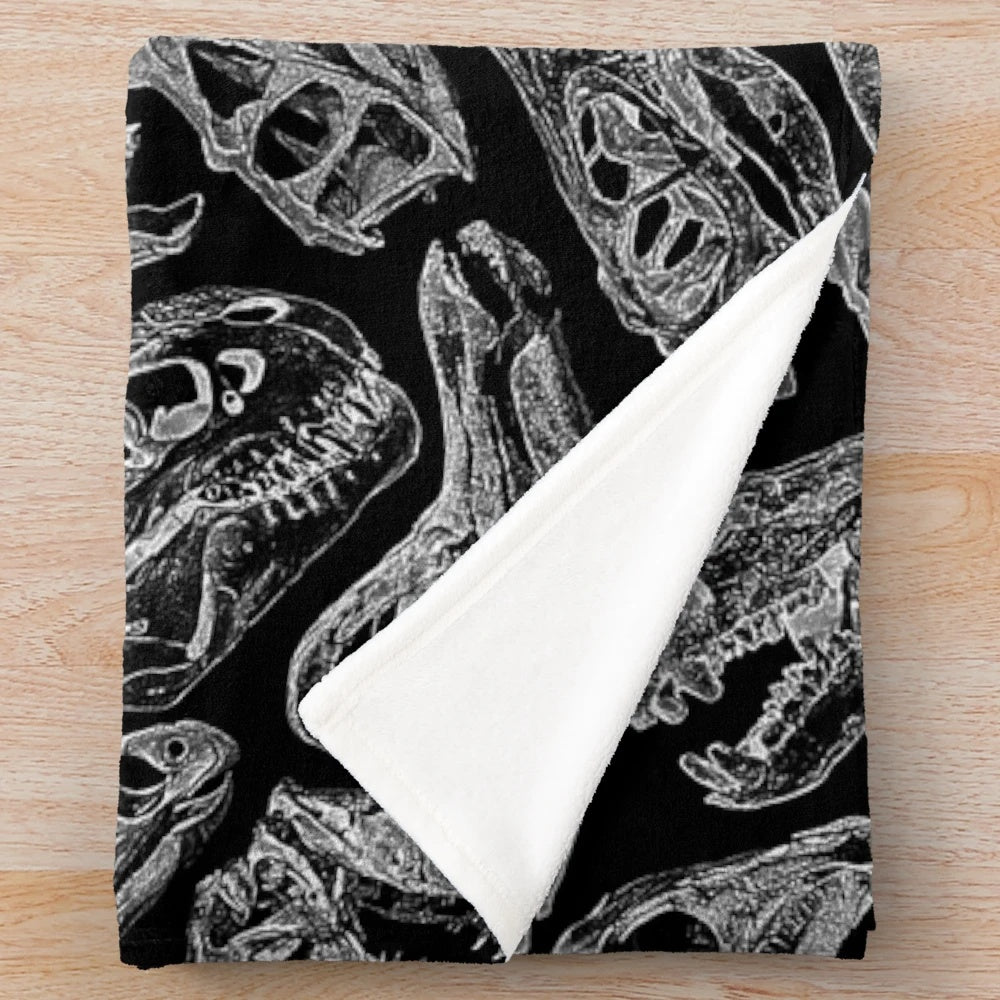 Plush blanket featuring a paleontology-inspired design with dinosaur fossils and skeletons