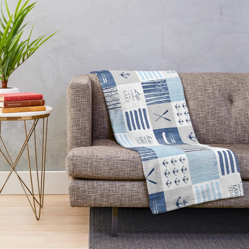 Patchwork blanket with lake, cabin, and water sports motifs