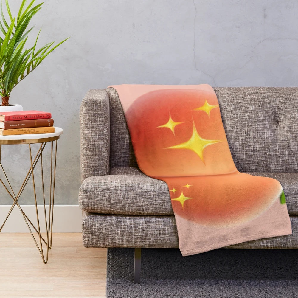 Peach plush blanket with a playful peach emoji design