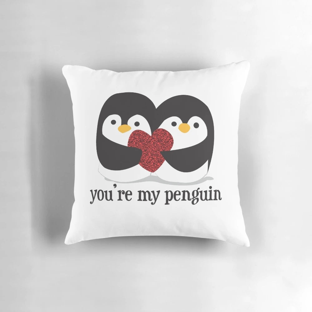 A cuddly black and white penguin pillow with a red heart, showcasing a romantic love quote