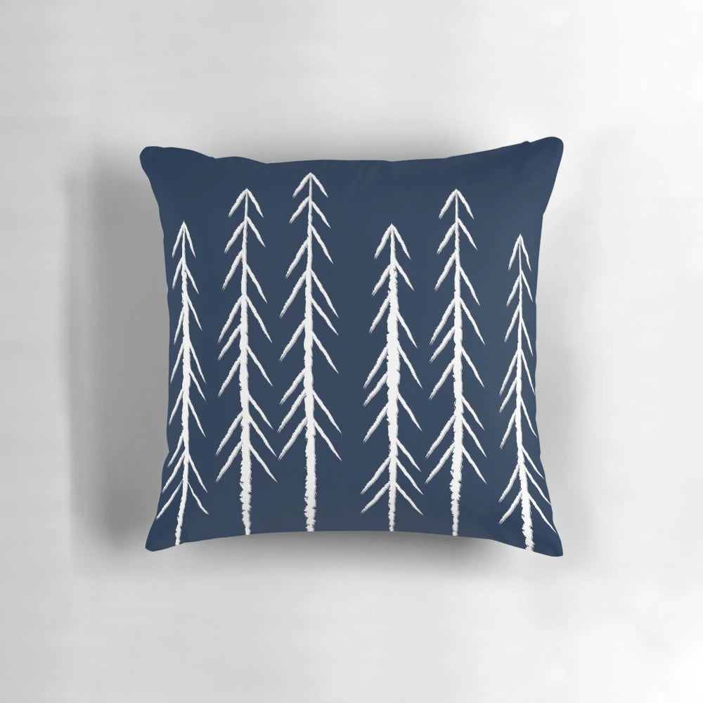 A navy blue and grey pillow with a sketch-style pine tree design and white arrows
