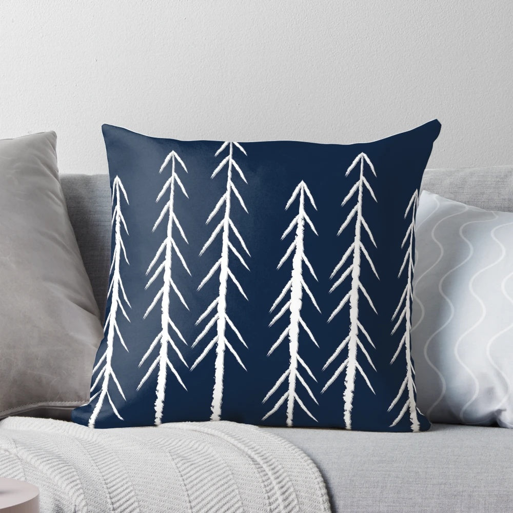 A navy blue and grey pillow with a sketch-style pine tree design and white arrows