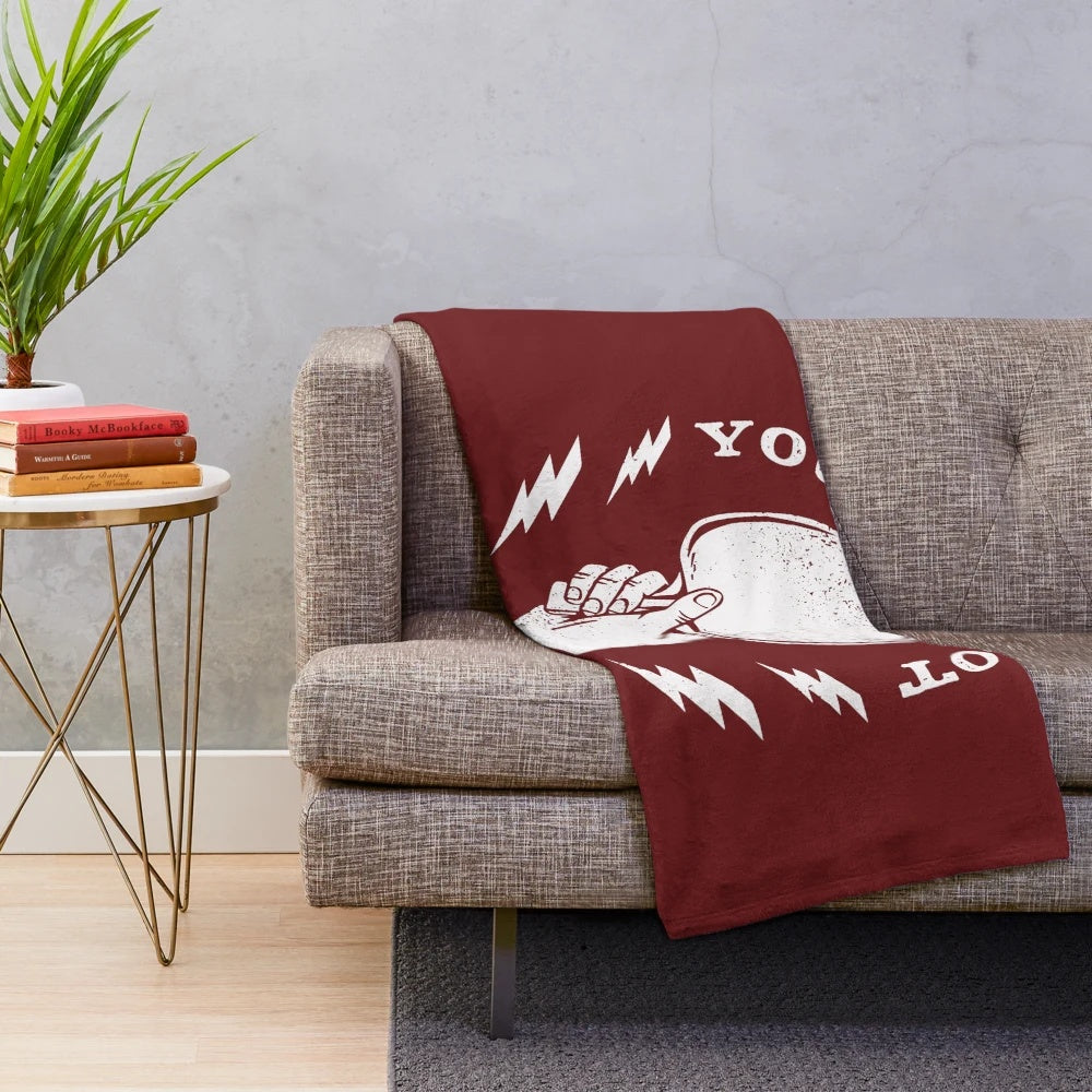 A plush blanket featuring a hand holding a ping pong paddle