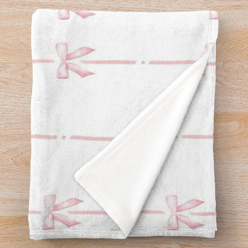 Soft and plush pink blanket with ribbon accents, perfect for a girl's bedroom in a coquette or y2k style.