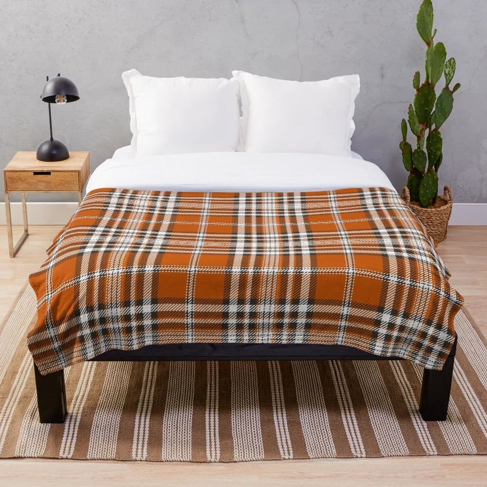 Autumn-inspired plaid plush blanket with an orange and red pattern