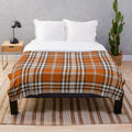 Autumn-inspired plaid plush blanket with an orange and red pattern