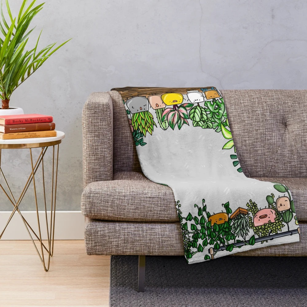 Plush plant-themed blanket with illustrations of houseplants