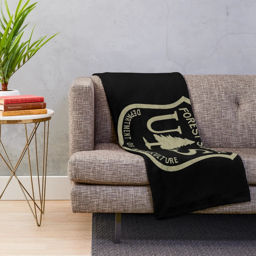 Plush blanket featuring the US Forest Service logo and imagery