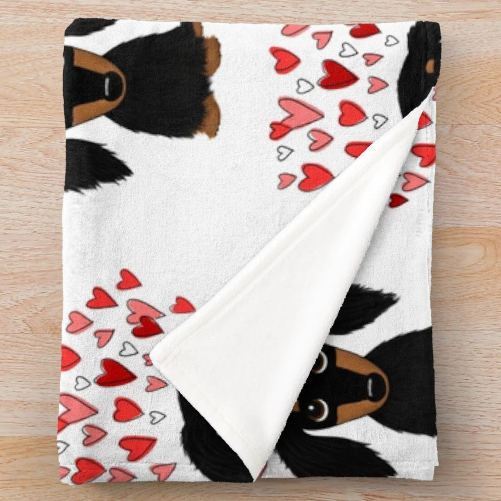A soft and plush blanket featuring an adorable long-haired dachshund dog in black and tan colors