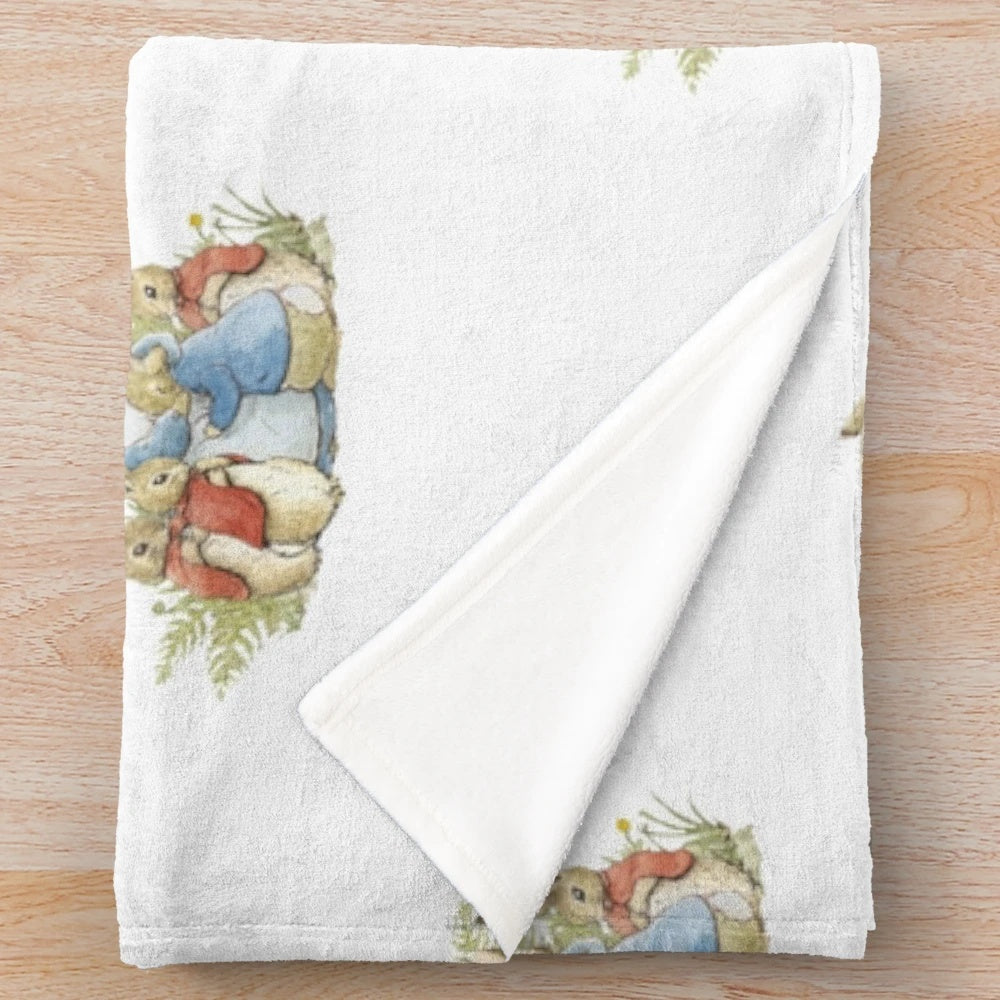 Plush blanket with illustration of Peter Rabbit and his family