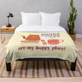 Plush blanket with books, coffee, and cat imagery