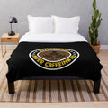 Plush blanket for coffee lovers with "Overworked, Under Caffeinated" design