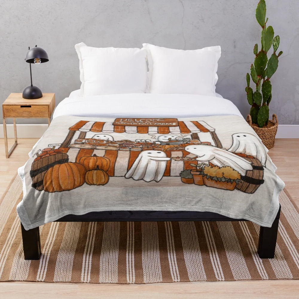 Soft and plush blanket in fall-inspired design with ghosts and pumpkins