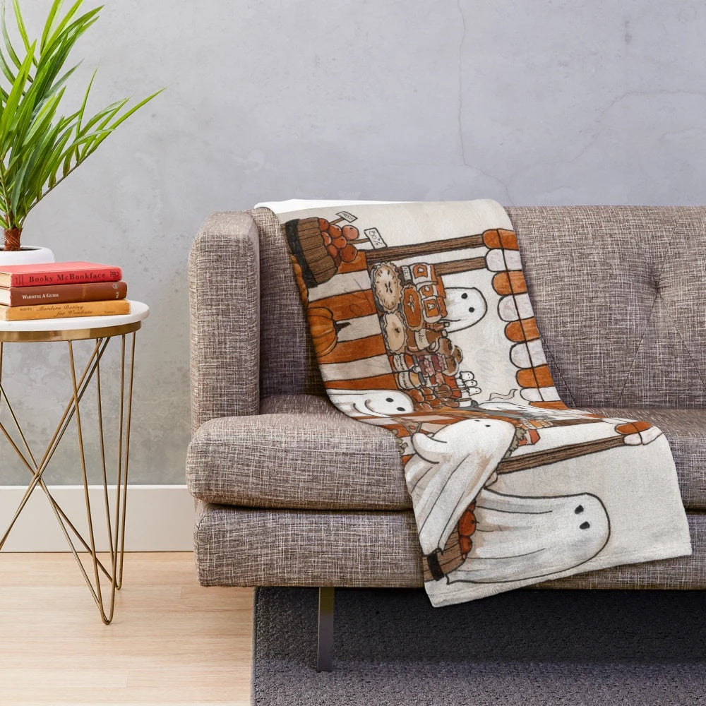 Soft and plush blanket in fall-inspired design with ghosts and pumpkins