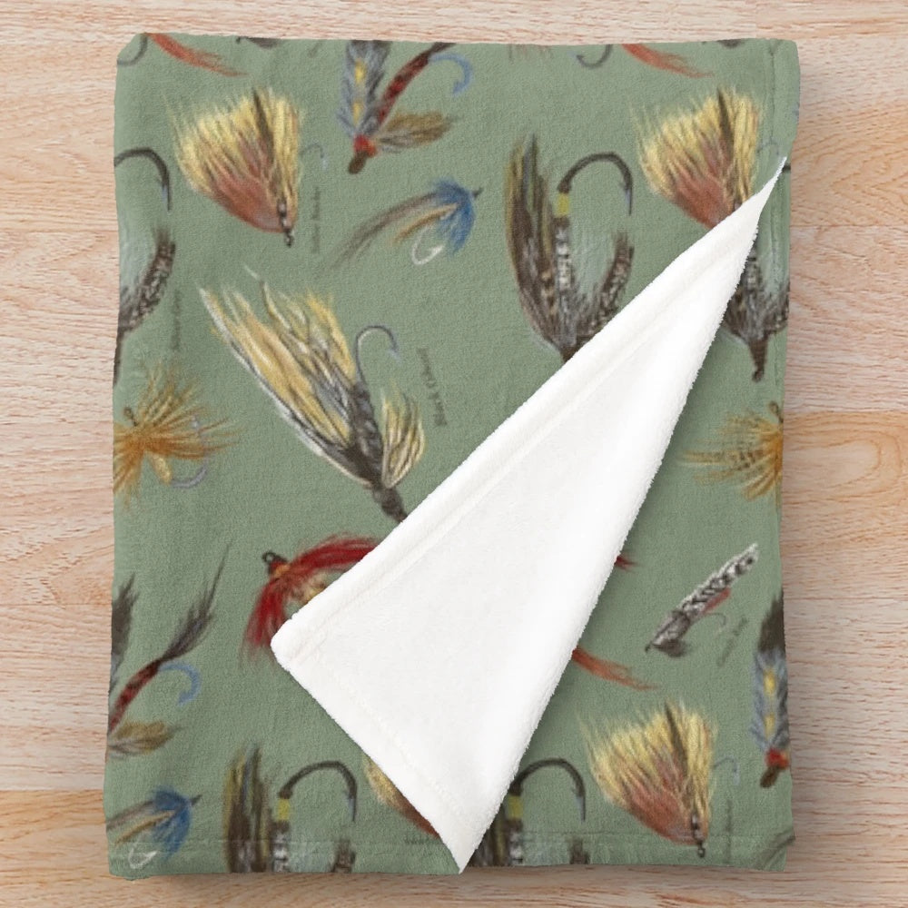 Plush blanket featuring hand-tied fishing flies and woodland design