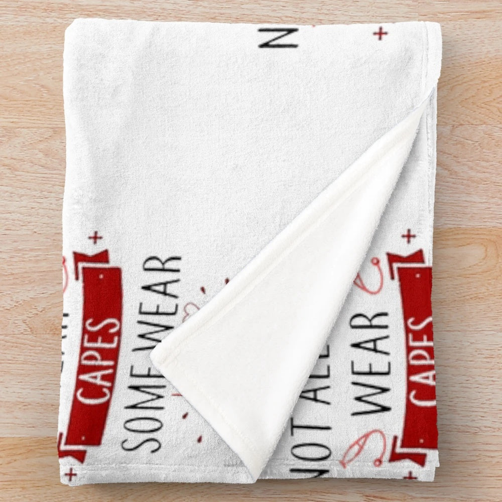 Plush blanket with "Not All Heroes" design for healthcare workers