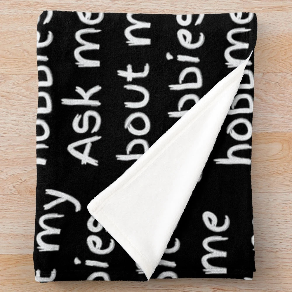 Plush blanket with "Ask me about my hobbies" design
