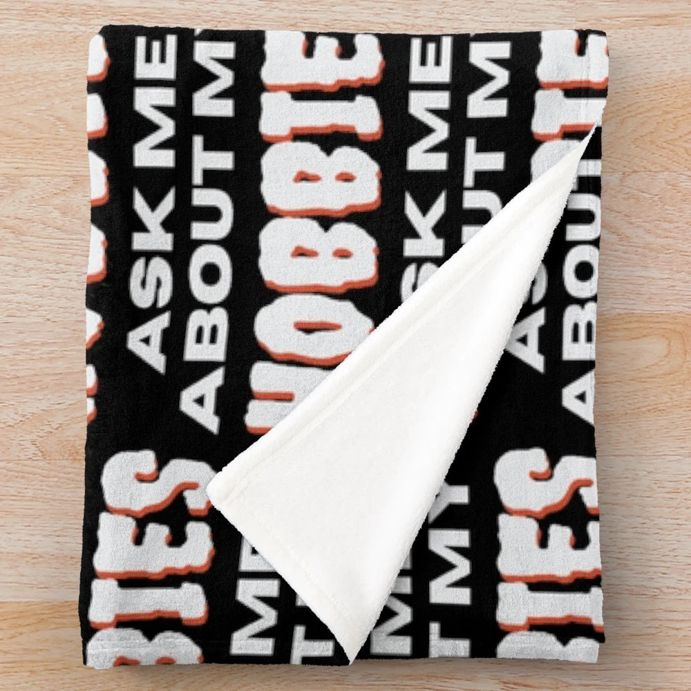 Plush blanket with "Ask me about my hobbies" design