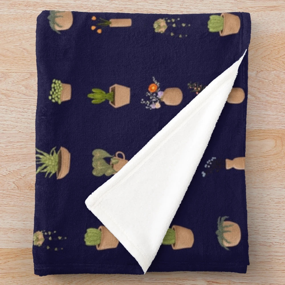 Plush blanket with a design featuring potted plants and gardening tools