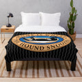 Greyhound, whippet, or lurcher dog sleeping on a soft, plush blanket with a cartoon design
