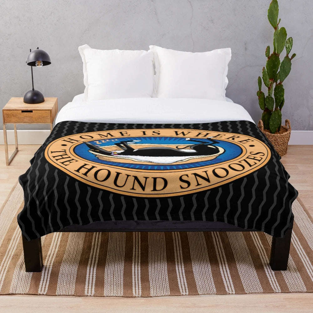 Greyhound, whippet, or lurcher dog sleeping on a soft, plush blanket with a cartoon design