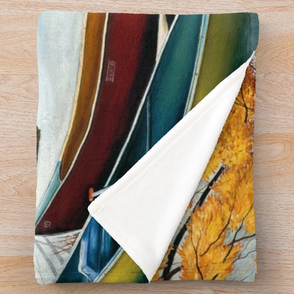 Plush blanket featuring artwork of a canoe on a river in autumn
