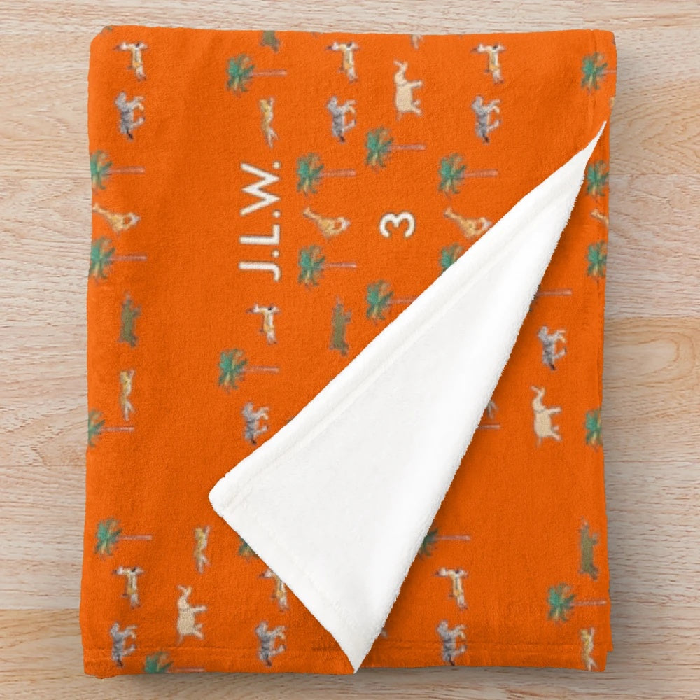 Plush blanket with Wes Anderson-inspired Darjeeling Limited luggage pattern