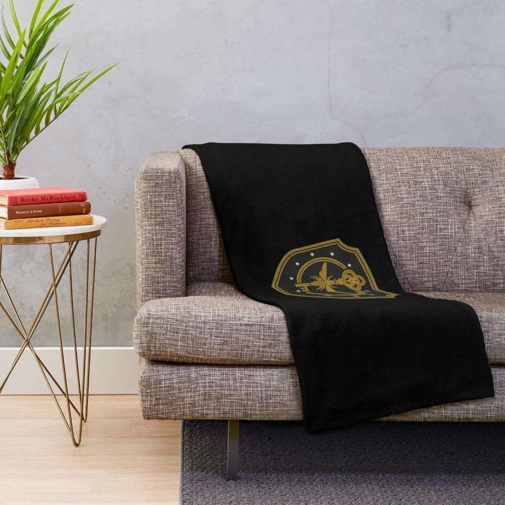 Plush blanket featuring The Magicians characters and Brakebills University logo