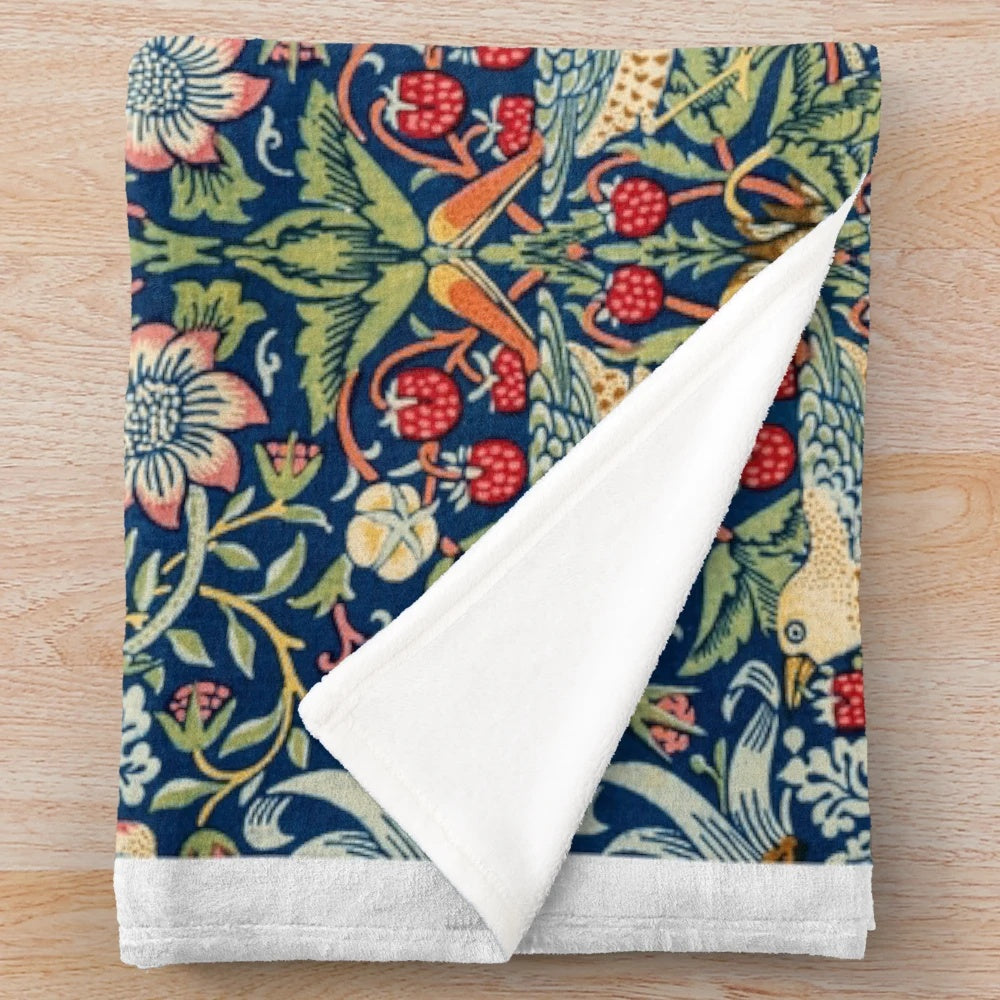 Closeup of the Strawberry Thief plush blanket featuring a floral and bird pattern