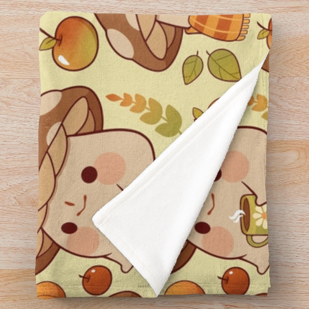 Plush blanket with whimsical mushroom and frog pattern in fall colors