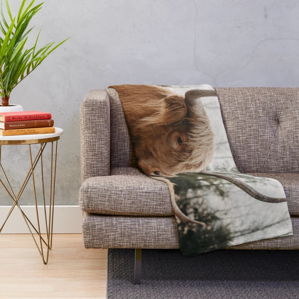 Plush blanket featuring a dramatic portrait of a highland cow in a scenic countryside landscape