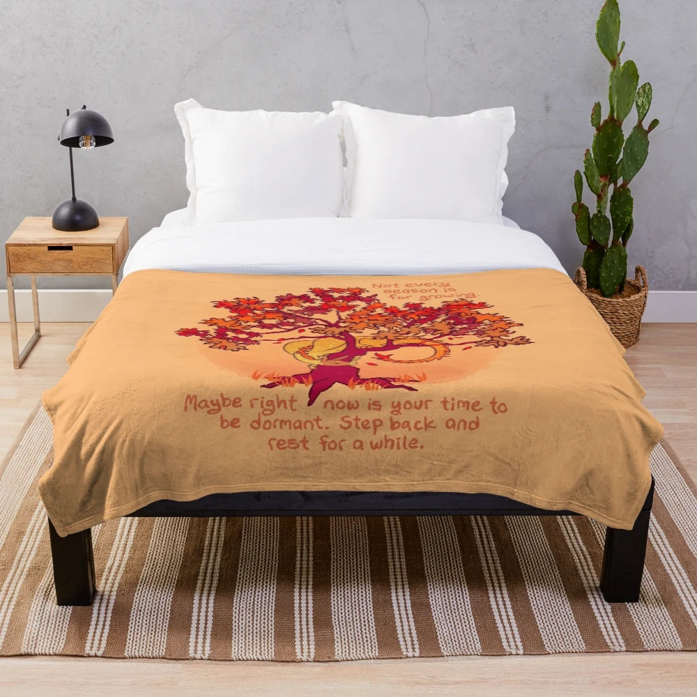 Plush blanket with a whimsical fall dragon design amid autumn leaves