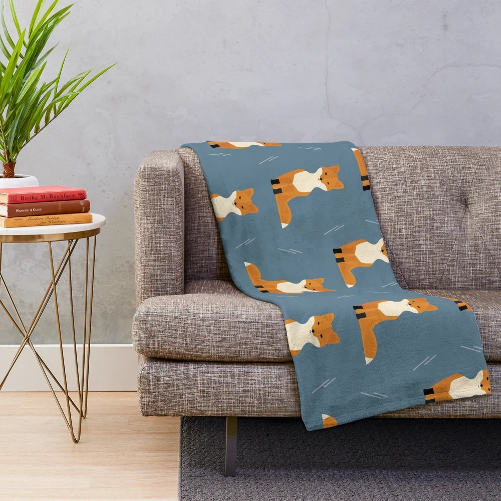 Plush blanket featuring a pattern of foxes in an autumn forest scene