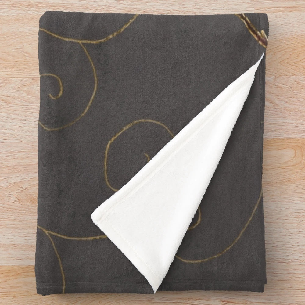 Plush blanket featuring a maple leaf design with gold filigree on a gray background