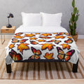 Plush blanket featuring monarch butterflies and vibrant orange fall leaves