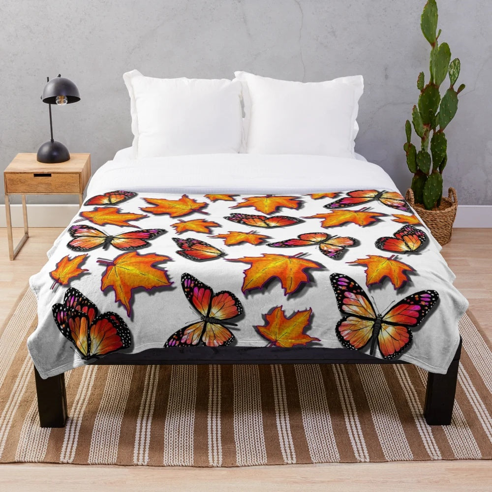 Plush blanket featuring monarch butterflies and vibrant orange fall leaves