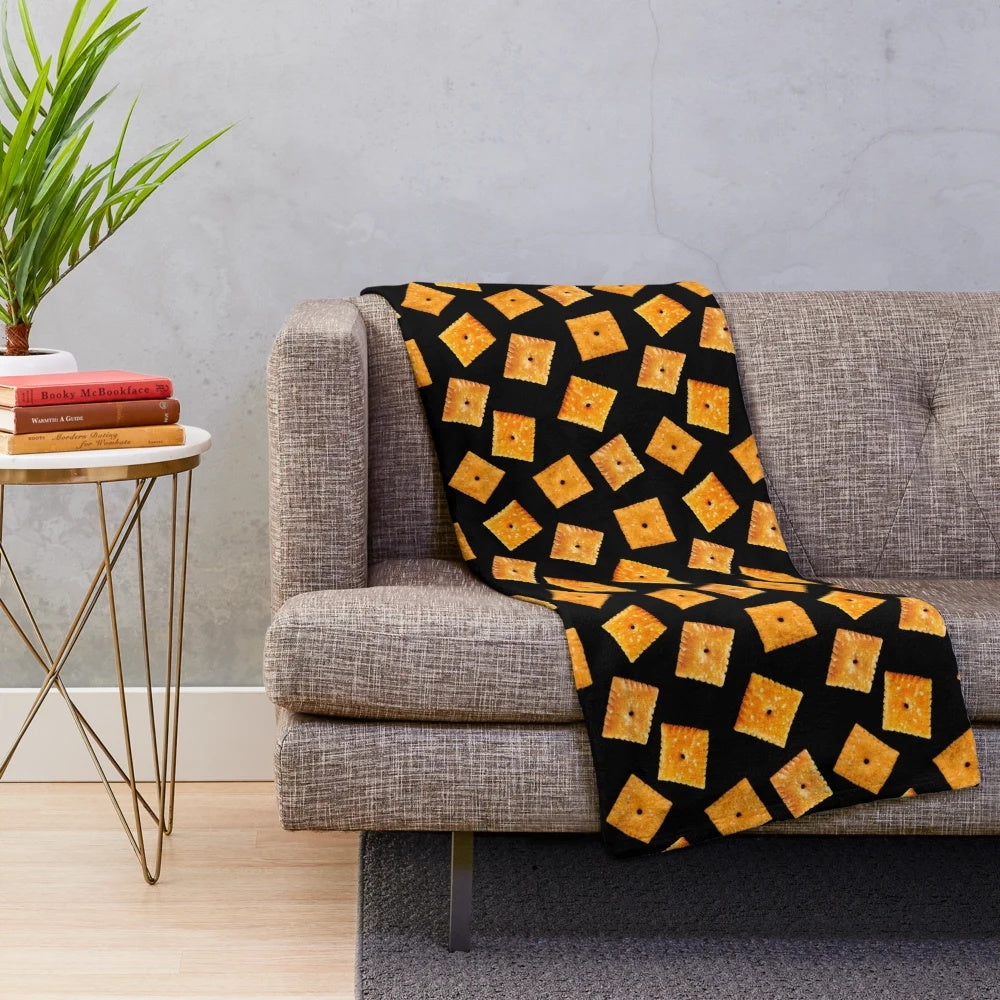 Plush black blanket with an orange square snack pattern design
