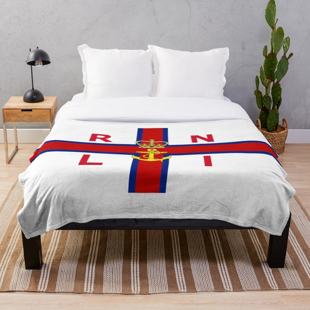 Plush blanket with coastal scene inspired by the Royal National Lifeboat Institution flag