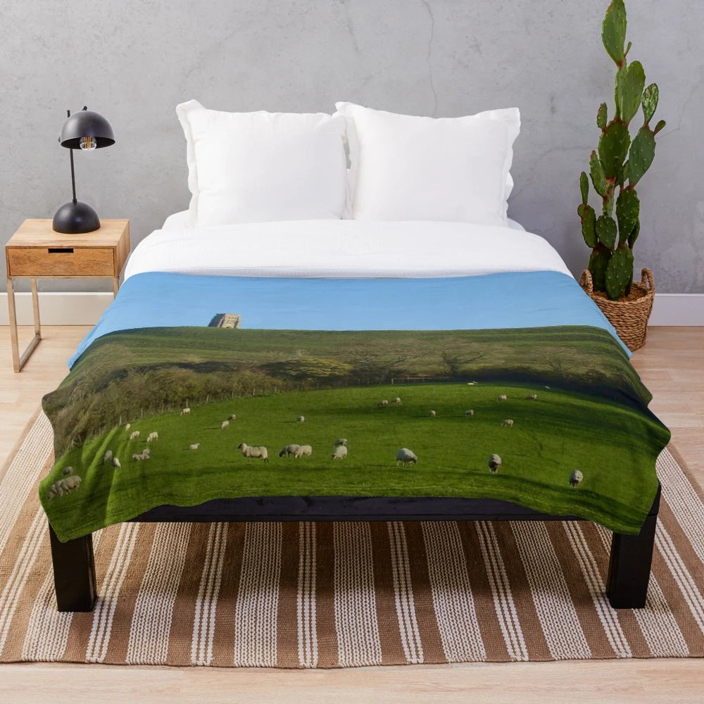 Plush blanket featuring sheep grazing in a countryside landscape at Glastonbury Tor