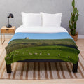 Plush blanket featuring sheep grazing in a countryside landscape at Glastonbury Tor